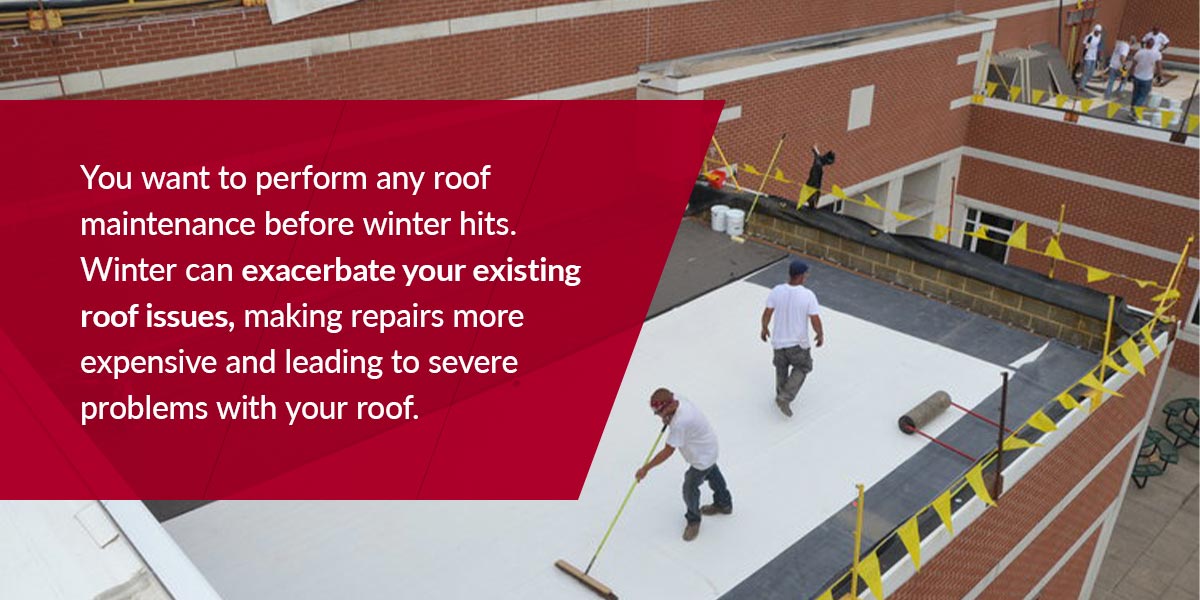 Professional roofers performing maintenance on a flat commercial roof